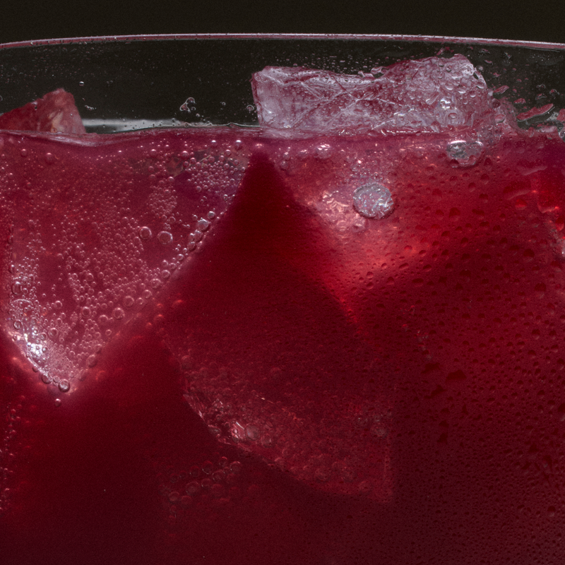 Close-up of ice cubes in a glass of deep red Ghia Blood Orange spritz