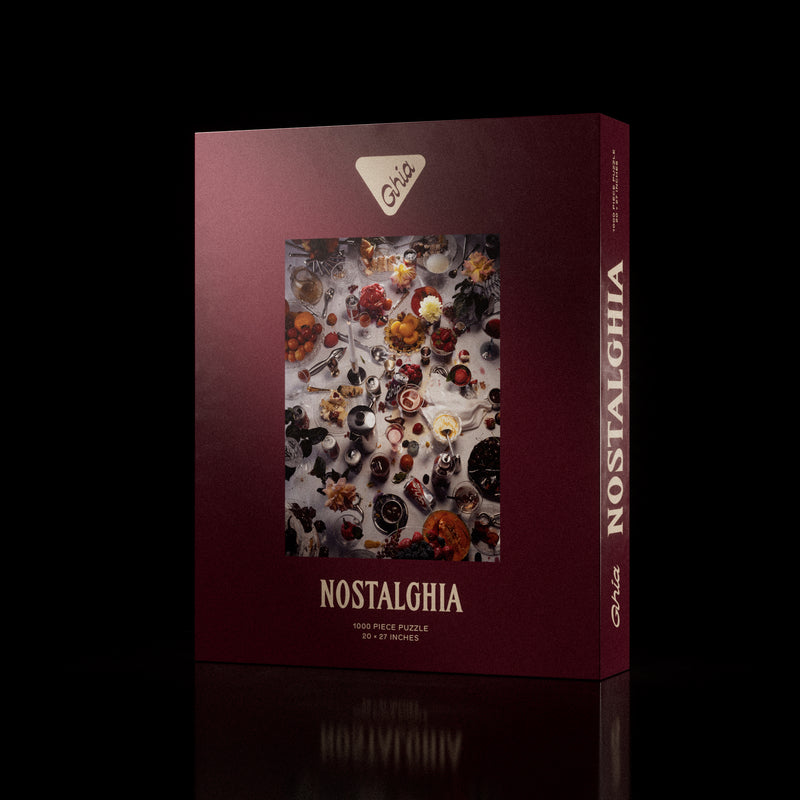 Ghia "Nostalghia" 1000-piece puzzle box featuring a detailed illustration of a vintage tabletop scene with drinks, snacks, and playing cards.